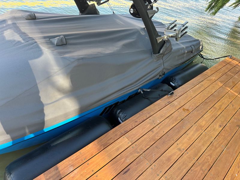 Customer photo of Hauraki inflatable fenders, fender covers and other inflatable marine products in use  overed boat on a wooden dock by water
